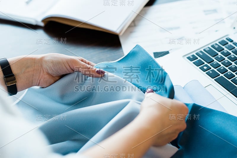 年轻的女设计师比较两个纺织品样品，同时选择其中之一