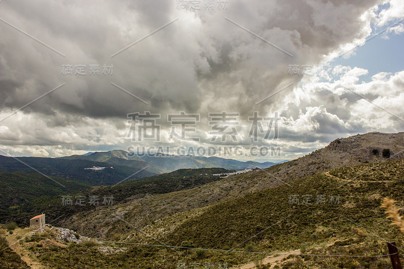 山景上的蓝色多云的天空背景。风景如画的群山在阳光下闪闪发光。令人屏息的自然影像