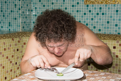 一个饥饿的男人和一盘蔬菜。