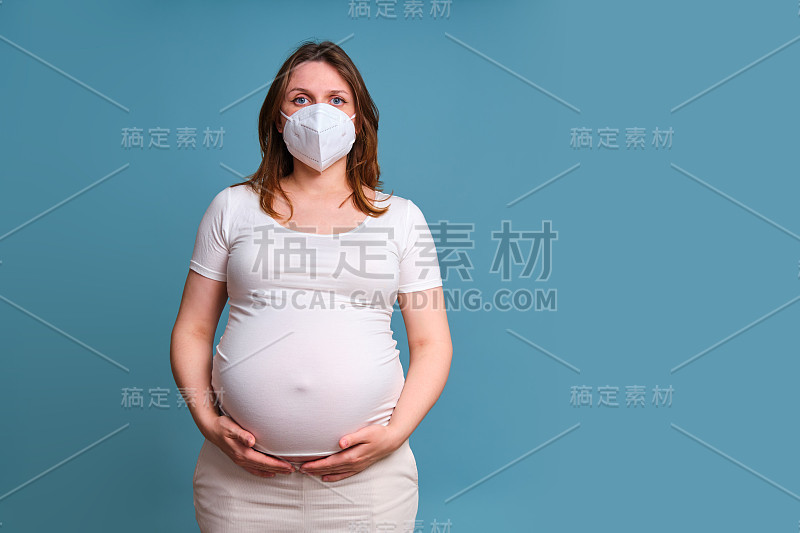 医用口罩n95孕妇脸上，工作室在蓝色背景下拍摄