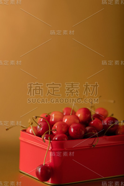红色金属盒子里的樱桃，金色背景。