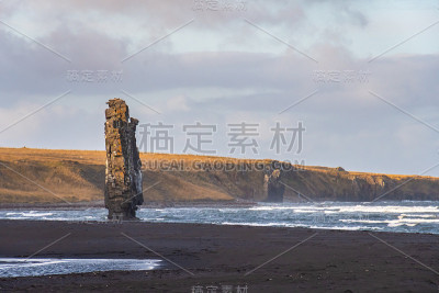 冰岛的Hvitserkur岩层矗立在波涛汹涌的大海中，前方是黑色的沙滩