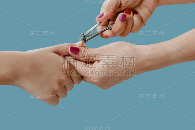 女人的手正在用指甲钳剪孩子的指甲