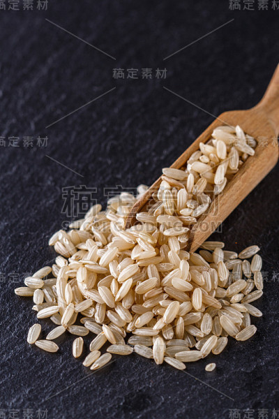 黑色石头背景上的生糙米