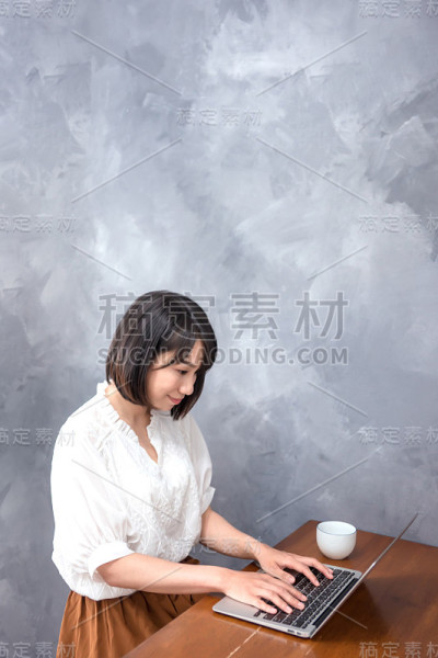 美丽的亚洲女孩与笔记本电脑在咖啡馆，教育或科技或创业的商业概念，现代办公室或客厅与复印空间
