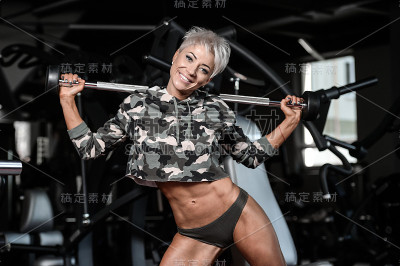 金发性感的运动年轻女孩在健身房锻炼