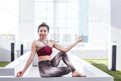 一个在大窗户前练习瑜伽的女人