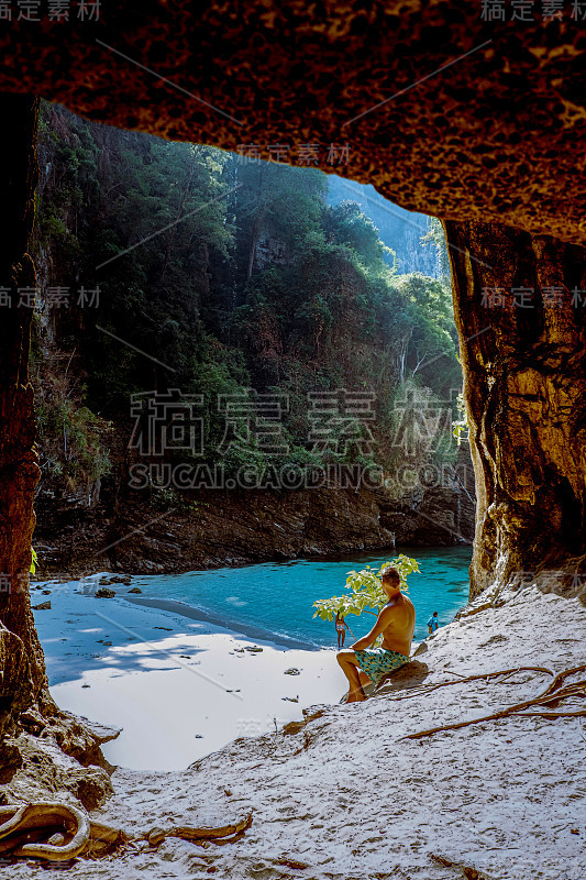 泰国甲米宝达岛附近有一个巨大的洞穴，隐藏的海滩，男子在石灰岩悬崖上望着泰国宝达甲米的秘密海滩