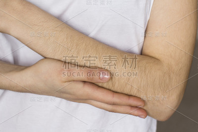 穿着白衬衫的年轻女子抚摸着自己的手
