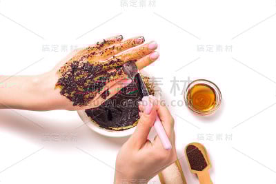 一名妇女用刷子在手上擦咖啡粉