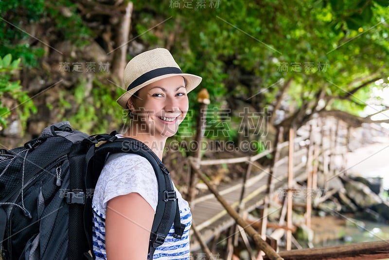 一个微笑的快乐女人的肖像与背包徒步旅行