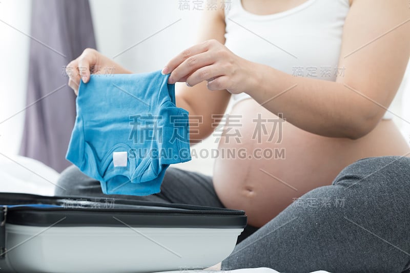 孕妇正在收拾婴儿衣服准备去妇产医院