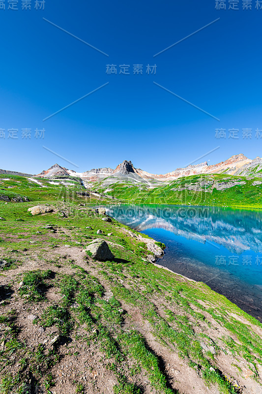 2019年8月夏天，科罗拉多州西弗顿附近的岩石山峰和积雪上的绿松石冰湖的垂直广角视图