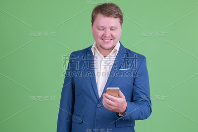 快乐的胖胡子商人用手机的肖像