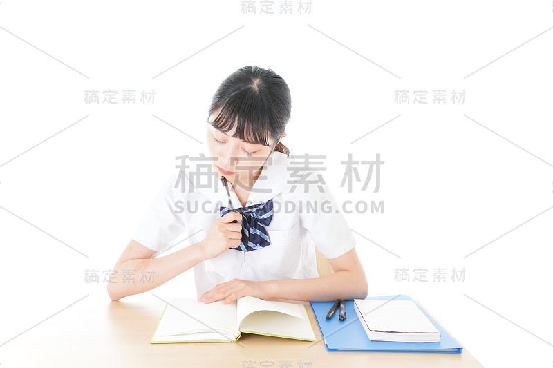 穿制服的年轻学生在书桌前学习