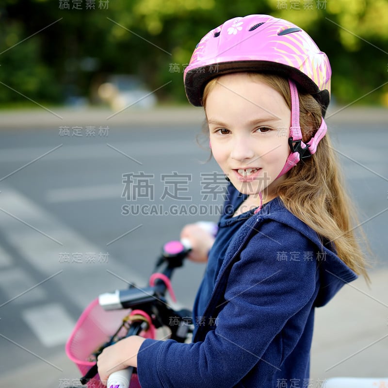 可爱的学龄前小女孩在城市里骑自行车