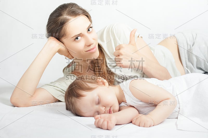 新生婴儿甜美的睡在白色的床上