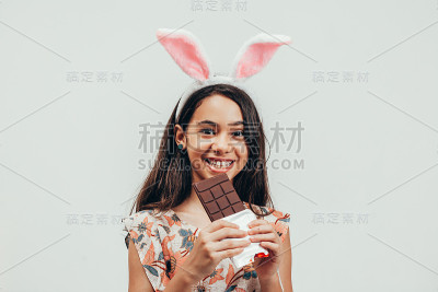 快乐的小女孩吃巧克力庆祝复活节的肖像