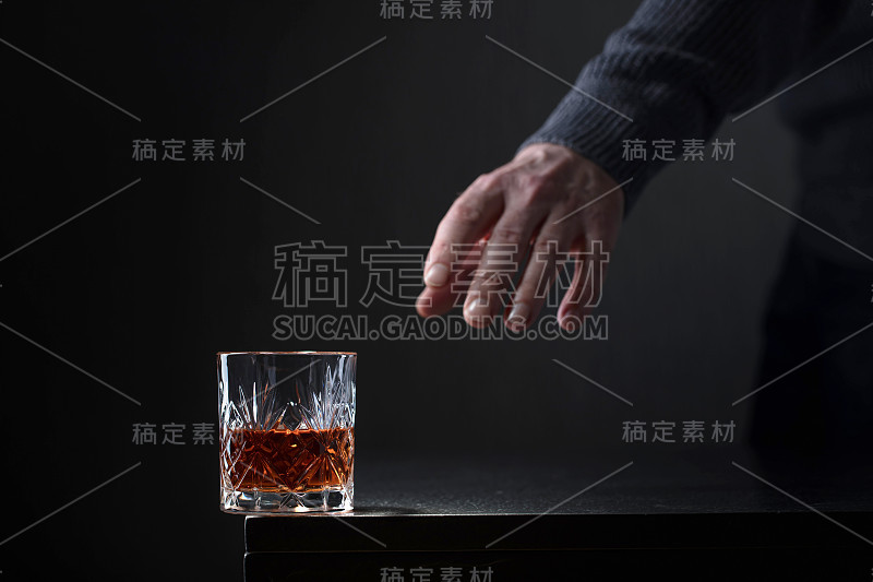 一个男人伸手去拿一杯酒。