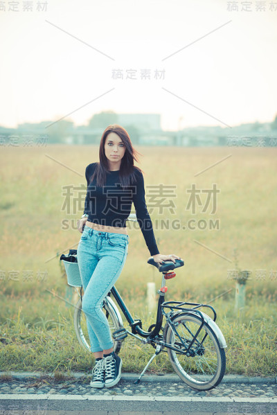 年轻漂亮的黑发直发女人使用自行车