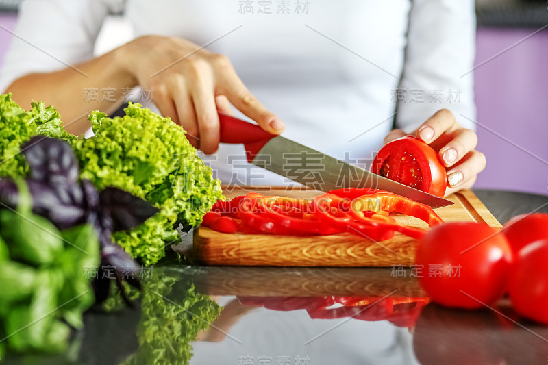 女厨师在厨房里切蔬菜。其理念是健康饮食，素食主义，减肥。