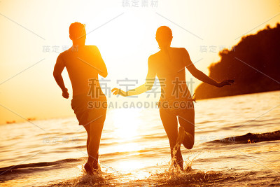 幸福夫妻奔向夕阳的海