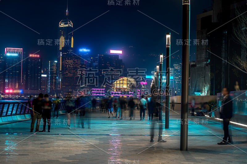 香港城市夜景。在海滨散步的游客