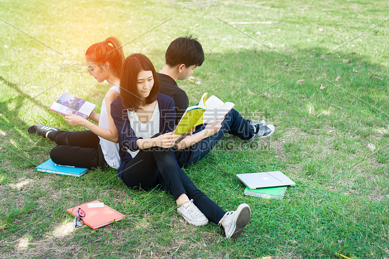 年轻的学生群与学校文件夹和笔记本电脑在草地上微笑的教育校园大学