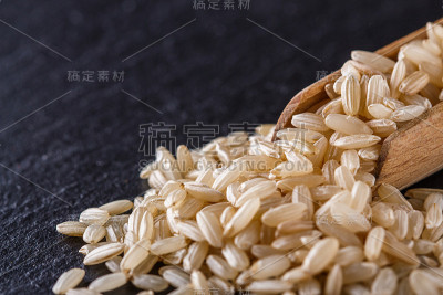 黑色石头背景上的生糙米