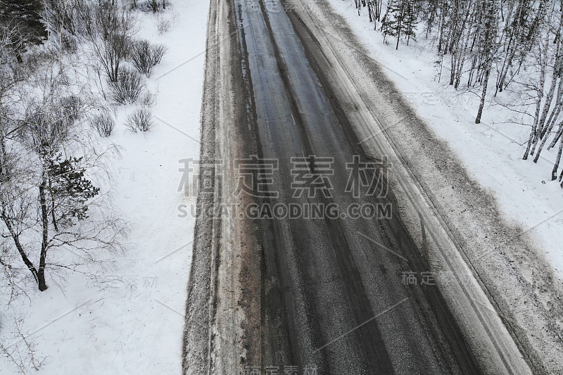 鸟瞰图一辆汽车在冬天的道路在森林。冬天的乡村景观。航拍雪域森林与汽车在道路上。无人机从上面拍下的