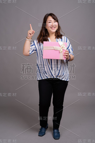 工作室拍摄的成熟美丽的亚洲女商人在灰色的背景