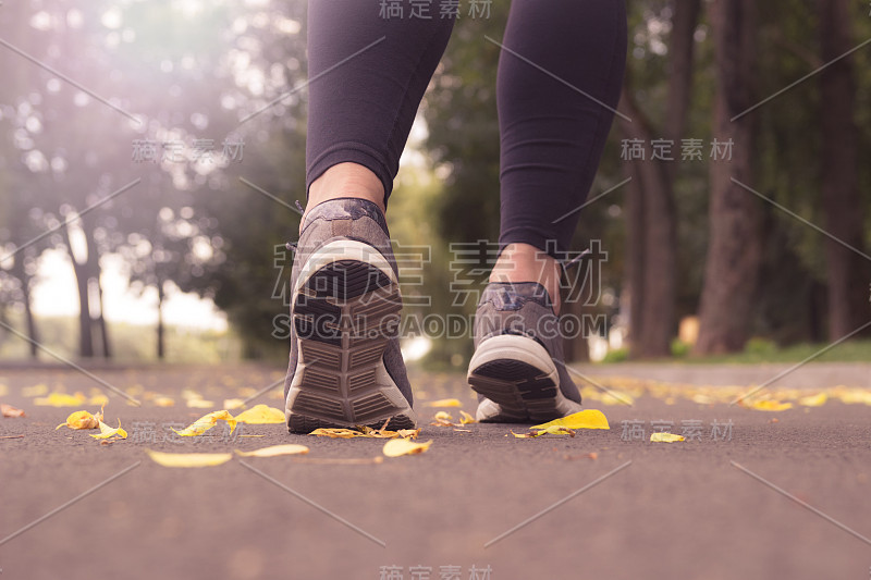 清晨在户外慢跑的年轻女子。运动鞋子。有氧运动。