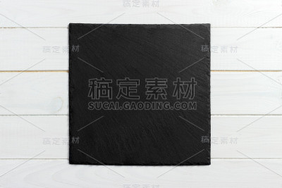 木制背景上的黑色石板石。本空间