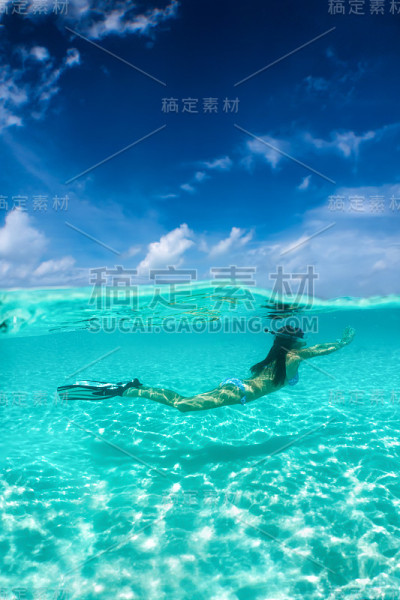 迷人的女人浮潜在热带水域