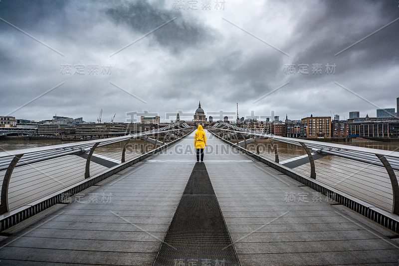 英国伦敦的一座桥上穿着黄色雨衣。