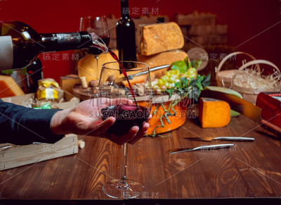 黑桌子上放着奶酪和葡萄酒。