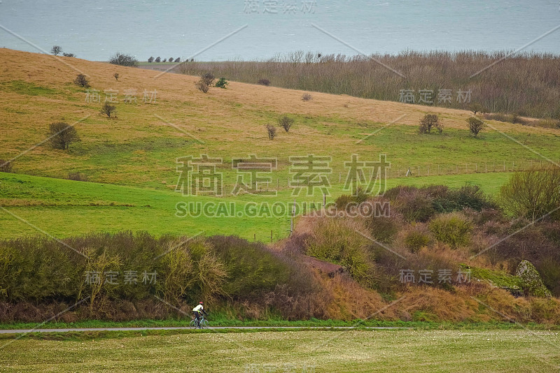 美丽的风景，一个男人在秋天的乡村公路上骑自行车