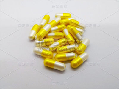 医疗保健理念。许多黄白色的氨甲环酸胶囊250毫克。白色背景上孤立，用于治疗月经期间大出血。选择性聚焦
