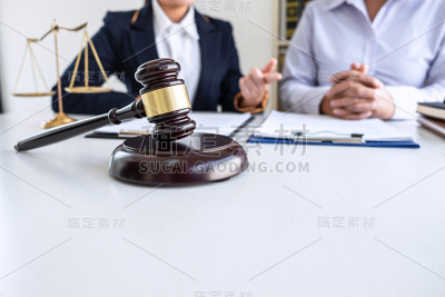 职业女性律师在法庭上与当事人会面讨论谈判案件，与文件接触，法律和公正理念