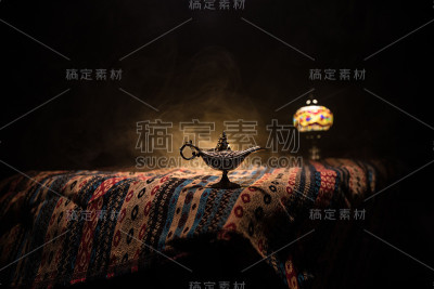 灯的愿望概念。古色古香的阿拉丁天方夜谭神灯，白烟柔和，背景幽暗。