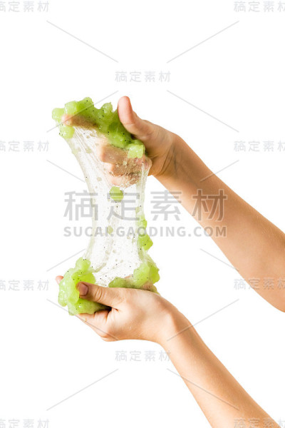 伸展到透明薄膜状态的绿色粘液在一个孩子的手中孤立在白色的背景上。