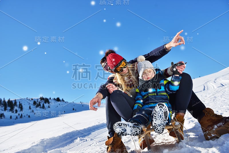 快乐的一家人在冬天的树林里坐雪橇，欢快的冬季娱乐