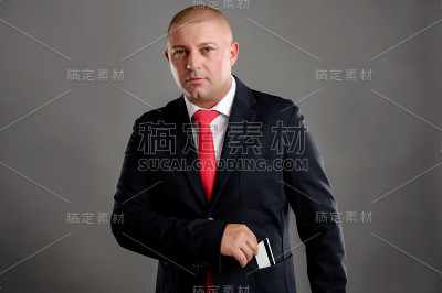 穿着黑色西装的商人从口袋里抽出一张卡片