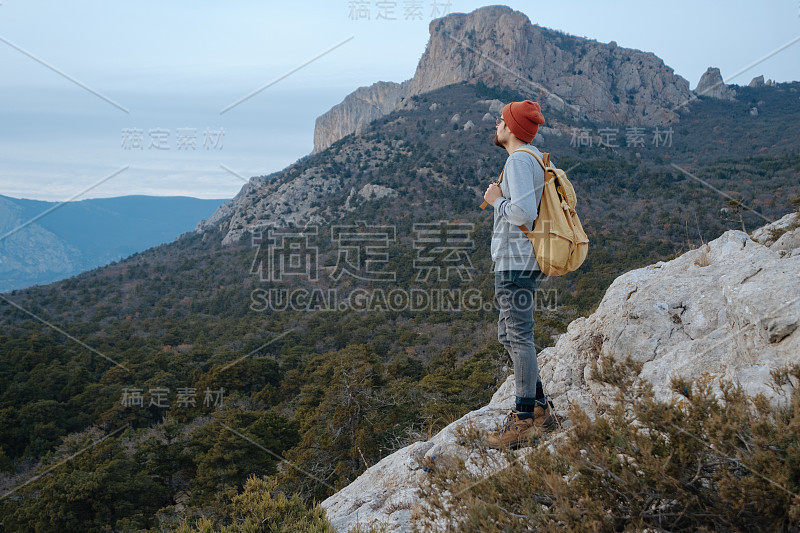 男人背包徒步旅行和红帽子在山区