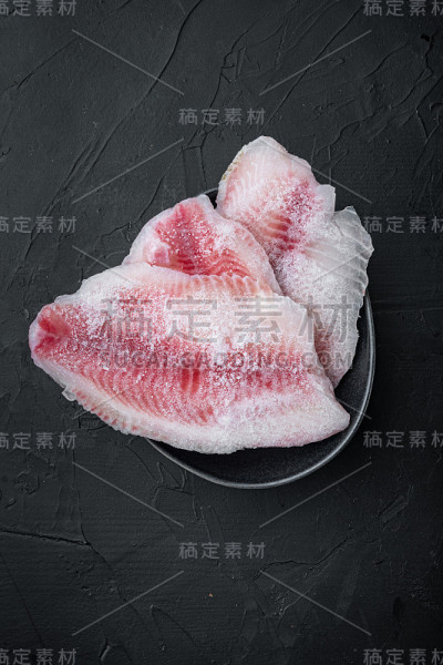 冷冻白鱼片，在黑色背景，俯视图