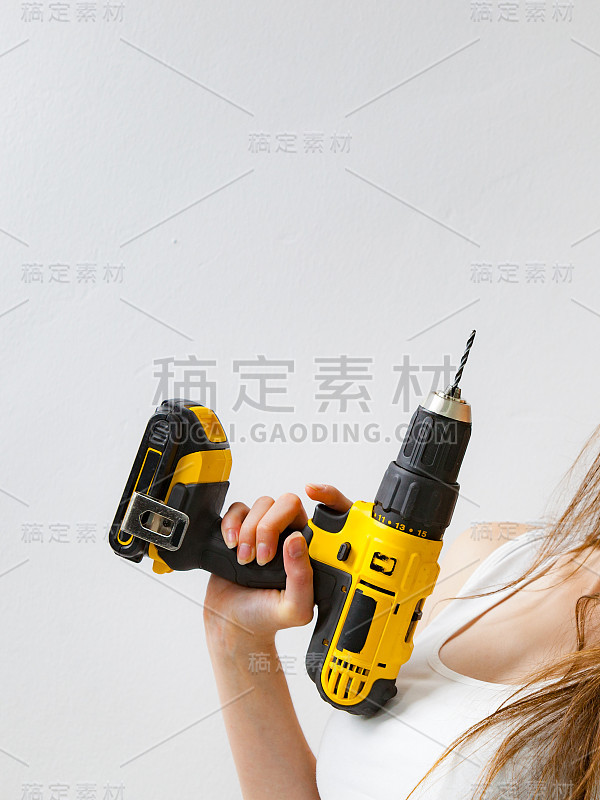 在家里用电钻工作的妇女