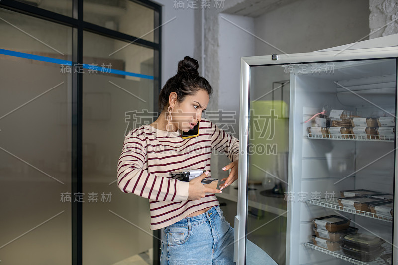 拿着饭盒，打手机的年轻女子