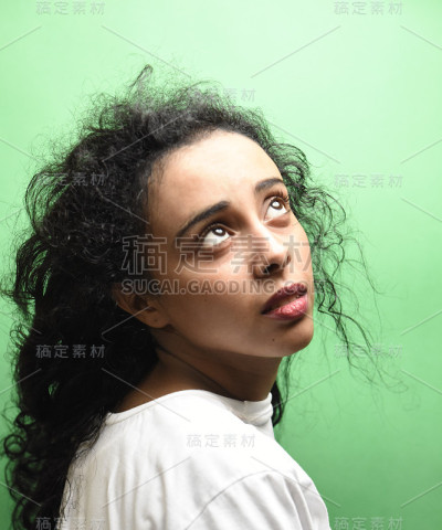 有着一头黑发的中东年轻女子。室内照片的奇妙女性模特在绿色的背景。
