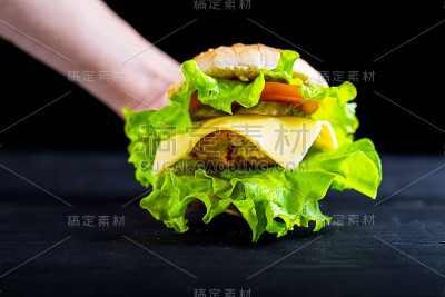 美味和新鲜的汉堡放在一个木制的黑色桌子上，广告横幅。