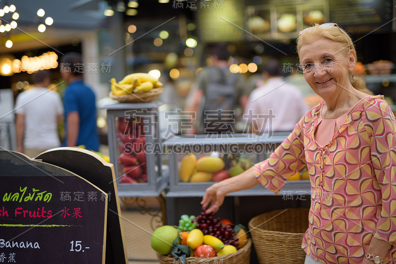 高级妇女的肖像与金发享受生活在暹罗广场在泰国曼谷